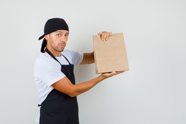 Hombre panadero con bolsa de papel en camiseta