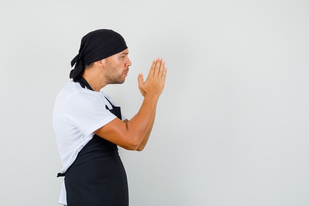 Hombre panadero cogidos de la mano en gesto de oración en camiseta