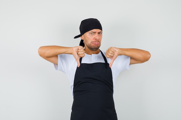 Foto gratuita hombre panadero mostrando doble pulgar hacia abajo en camiseta