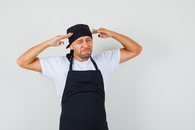 Hombre panadero sufre de fuerte dolor de cabeza en camiseta