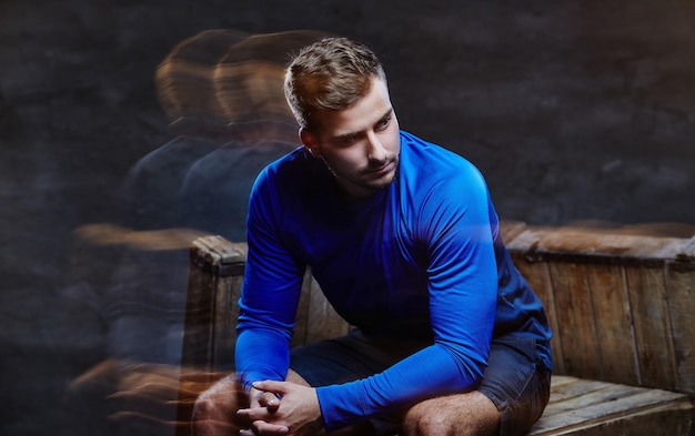 Un hombre con pantalones cortos y camiseta deportiva azul. en el estudio