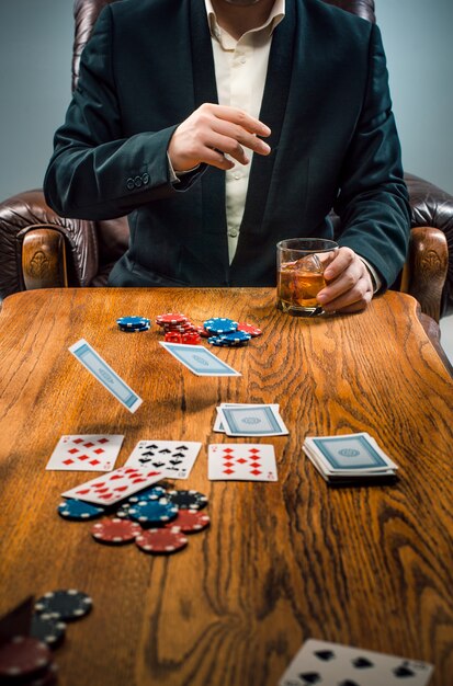 El hombre, papas fritas para jugar, beber y jugar a las cartas.