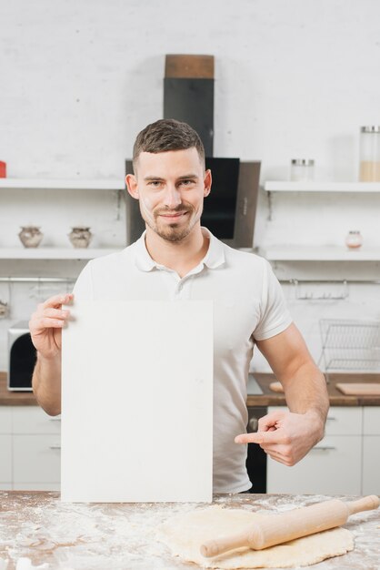 Foto gratuita hombre con papel en blanco en cocina