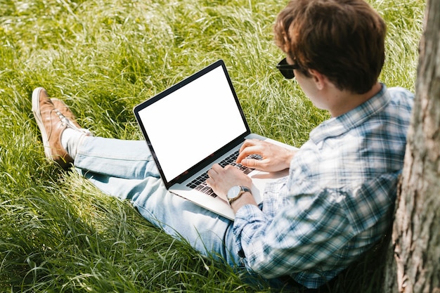 Hombre en el parque trabajando en la computadora portátil