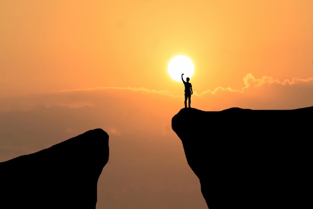 Foto gratuita hombre en la parte superior de la montaña, el hombre de la libertad en el fondo puesta del sol