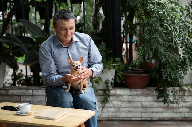 Hombre pasando tiempo con su perro en el jardín.