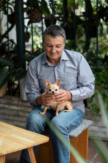 Hombre pasando tiempo con su perro en el jardín.