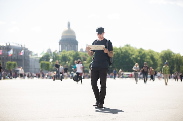 Foto gratuita hombre paseando y mirando un mapa