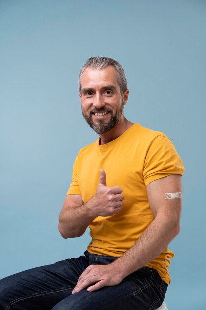Hombre con pegatina en el brazo después de recibir una vacuna