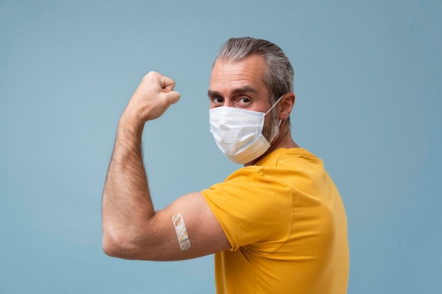 Hombre con pegatina en el brazo después de recibir una vacuna