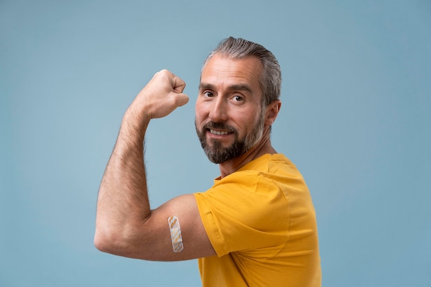 Hombre con pegatina en el brazo después de recibir una vacuna