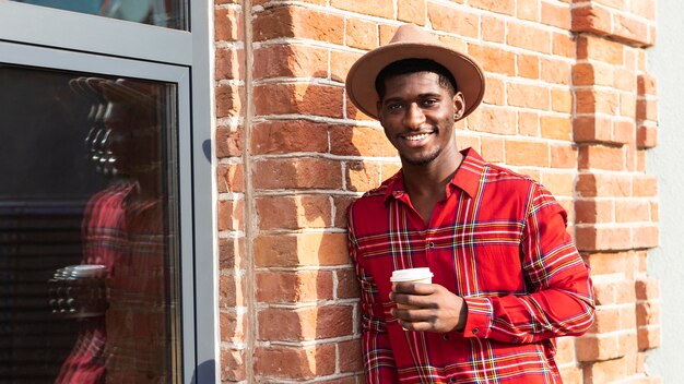 Hombre con pelo corto sosteniendo un café