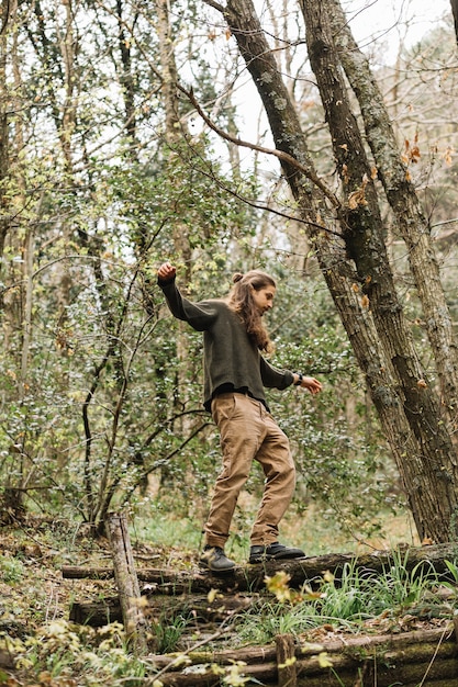 Foto gratuita hombre con pelo largo haciendo senderismo en la naturaleza