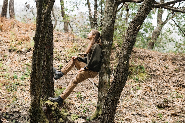 Hombre con pelo largo relajando en la naturaleza