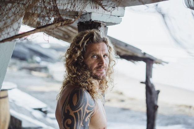 Foto gratuita un hombre con pelo largo y rizado en un lugar de pesca. pescador en el oceano