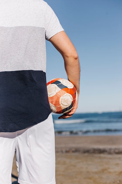 Foto gratuita hombre con pelota en la playa