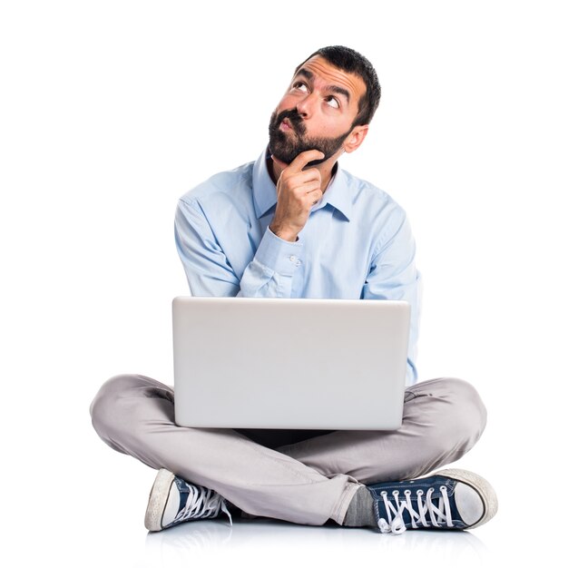 Hombre con el pensamiento de la computadora portátil