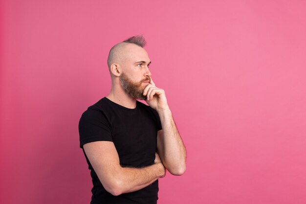 Hombre pensativo europeo en estudio sobre fondo rosa
