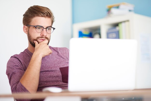 Hombre pensativo frente a computadora