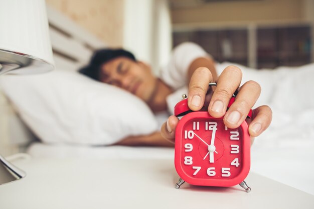 Hombre perezoso despertándose en su habitación.