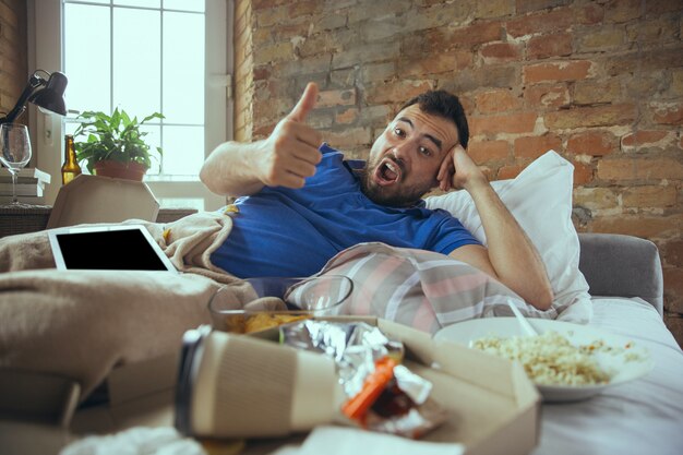 Hombre perezoso viviendo toda la vida en su cama rodeado de desorden