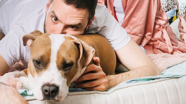 Foto gratuita hombre con perro en la cama