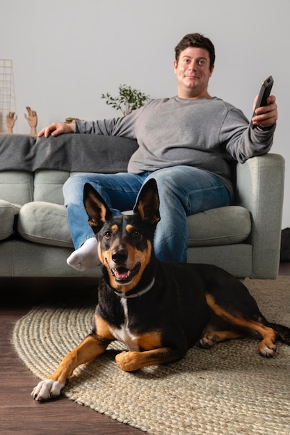 Hombre y perro de tiro completo en el interior