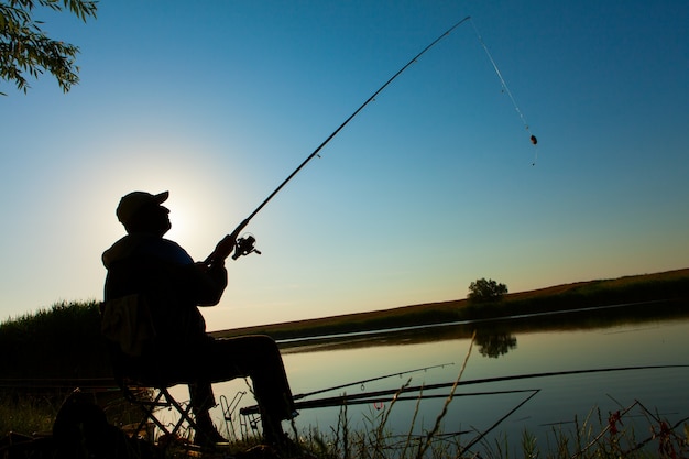 El hombre pesca en un lago