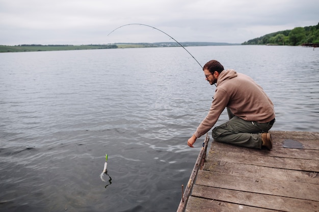 Hombre pescando con caña de pescar en el lago