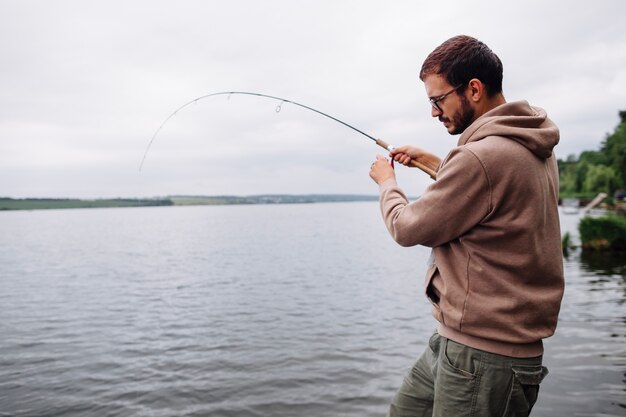 Hombre pescando en un lago idílico