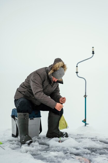 Hombre pescando solo afuera en invierno