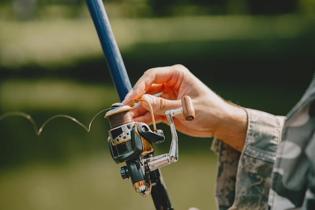 Hombre pescando y sostiene la caña de pescar