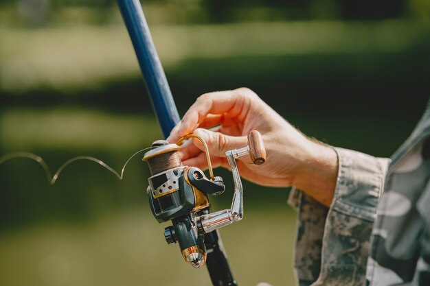 Hombre pescando y sostiene la caña de pescar