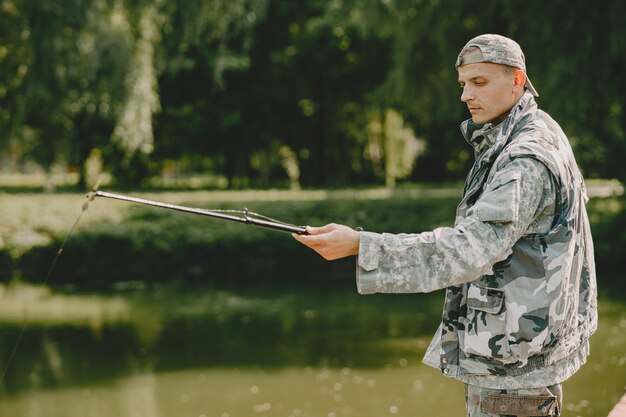 Hombre pescando y sostiene la caña de pescar