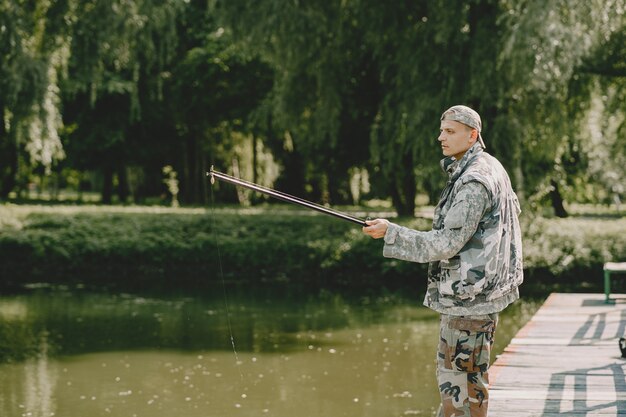 Hombre pescando y sostiene la caña de pescar