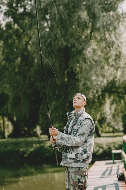 Hombre pescando y sostiene la caña de pescar