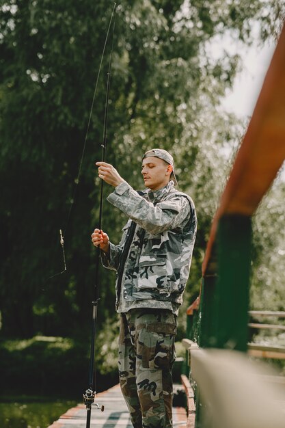 Hombre pescando y sostiene la caña de pescar