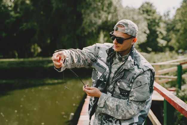 Hombre pescando y sostiene la caña de pescar