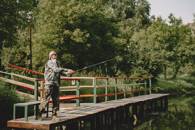 Hombre pescando y sostiene la caña de pescar