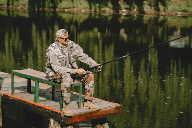 Hombre pescando y sostiene la caña de pescar