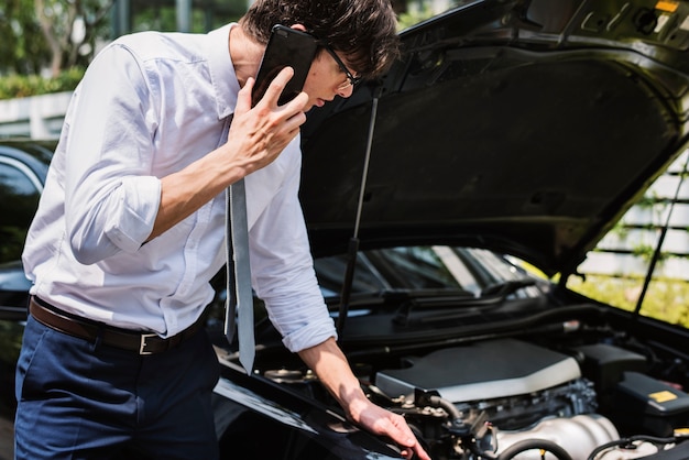 Foto gratuita hombre pidiendo ayuda para arreglar su auto