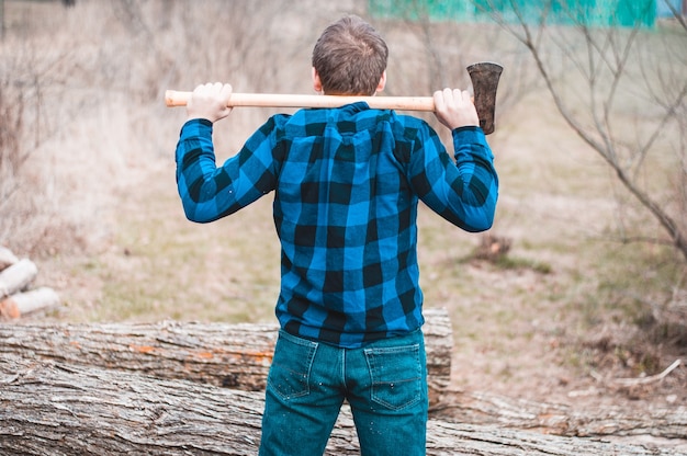 Hombre de pie en el bosque con su hacha