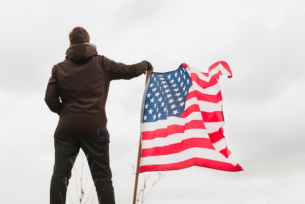 Foto gratuita hombre de pie, cerca, bandera estadounidense