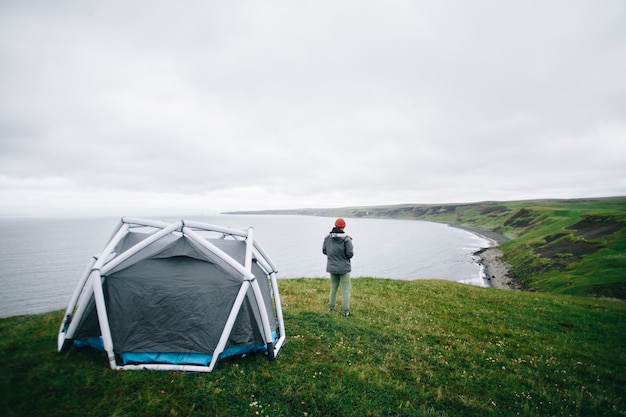 Hombre de pie junto a la carpa moderna en islandia