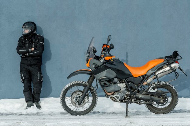 Hombre de pie junto a la motocicleta con casco