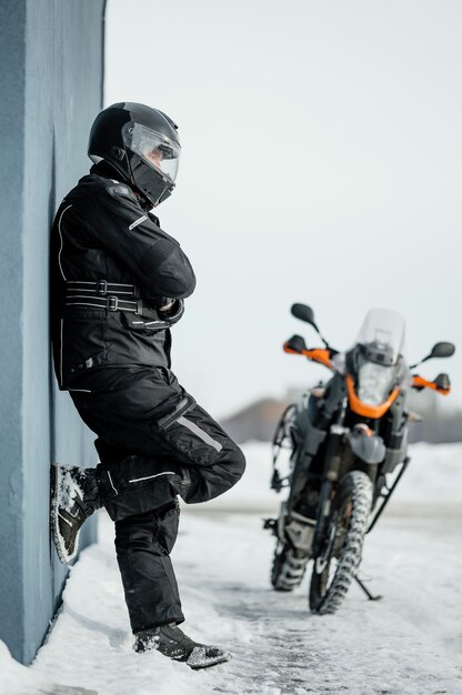 Hombre de pie junto a la motocicleta con casco