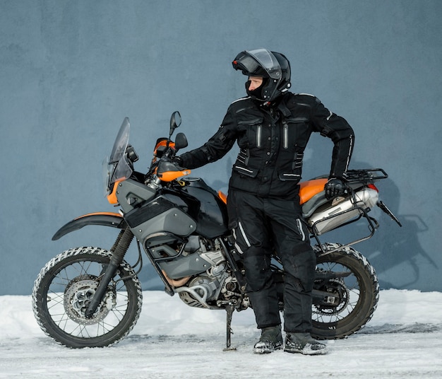 Hombre de pie junto a la motocicleta con casco