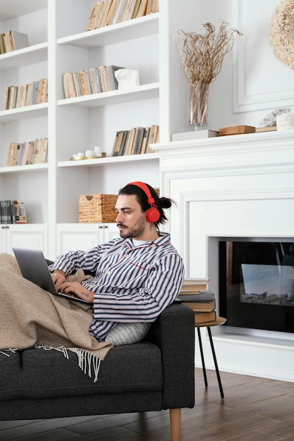 Foto gratuita hombre en pijama pasando su tiempo en interiores