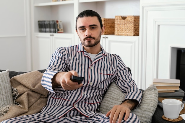 Foto gratuita hombre en pijama pasando su tiempo en interiores