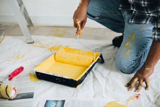 Foto gratuita hombre pintando las paredes de amarillo